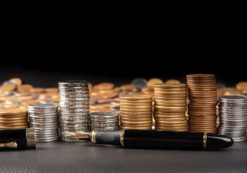 coins-brazilian-coins-various-amounts-piled-up-fountain-pen-black-leather-selective-focus-scaled-1.jpg